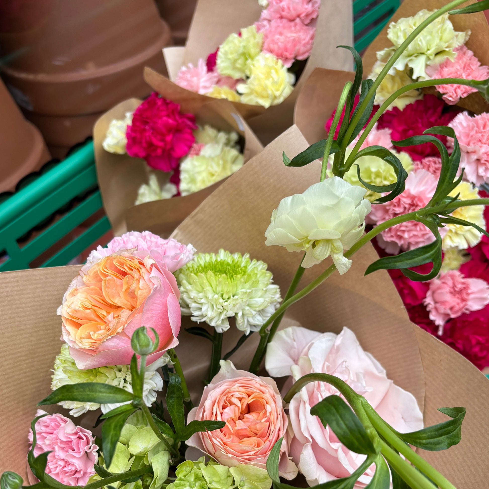 Bouquet of flowers with pink, green, and orange colors on a brown paper background.